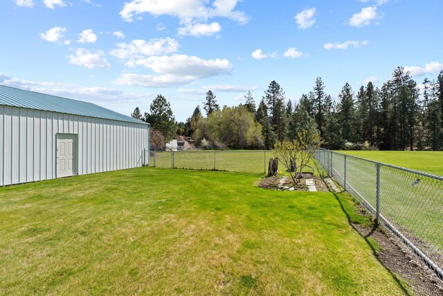 view of yard with a fenced backyard, an outdoor structure, and a pole building