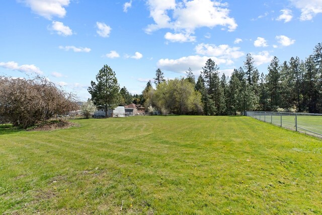 view of yard featuring fence and a rural view