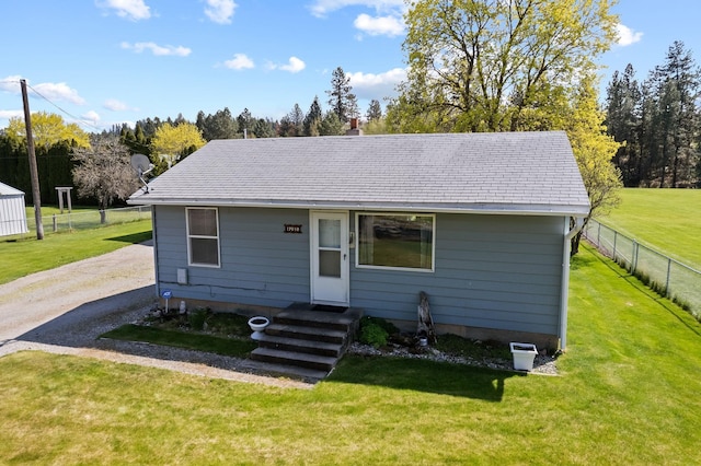 bungalow-style home featuring a chimney, fence, driveway, and a front yard