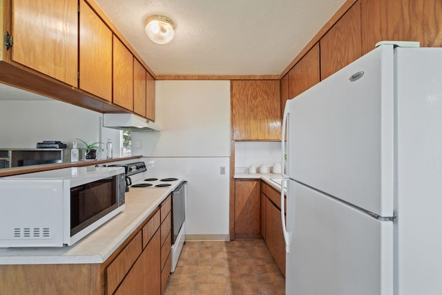 kitchen with under cabinet range hood, light countertops, white appliances, and brown cabinets