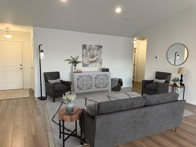 living room featuring wood finished floors, visible vents, and baseboards