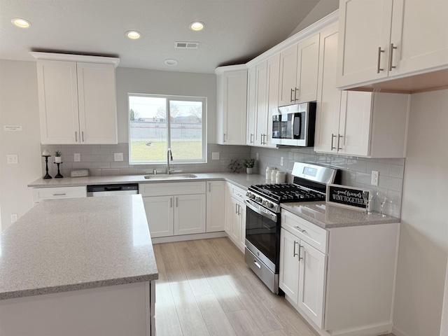 9520 E Michielli Ln, Spokane Valley, WA 99206 - kitchen with stainless steel appliances, white cabinetry, light stone countertops, recessed lighting, and light wood-type flooring