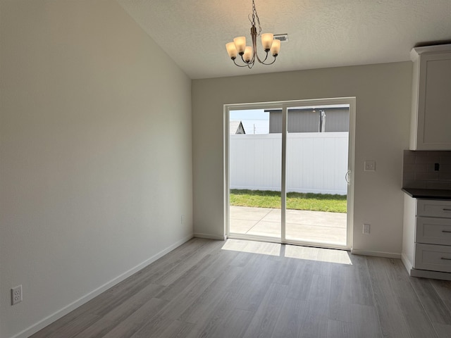 9520 E Michielli Ln, Spokane Valley, WA 99206 - unfurnished dining area with a chandelier, wood finished floors, and a textured ceiling