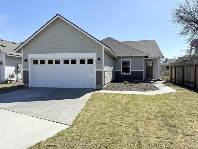 ranch-style house featuring a front lawn, concrete driveway, fence, a garage, and a shingled roof