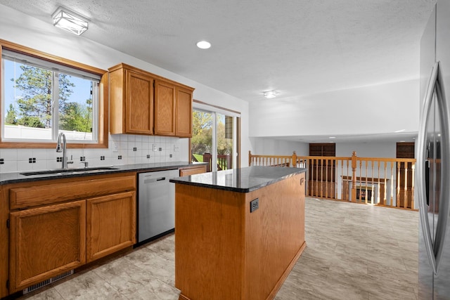 4604 E Birkdale Ln, Spokane, WA 99223 - kitchen with appliances with stainless steel finishes, decorative backsplash, brown cabinets, a center island, and recessed lighting