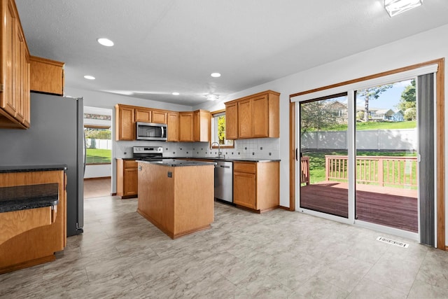 kitchen with a kitchen island, backsplash, appliances with stainless steel finishes, visible vents, and recessed lighting