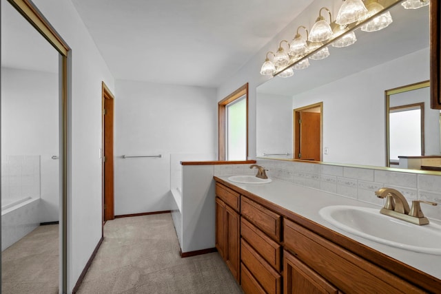 bathroom with a bath, a wealth of natural light, and a sink