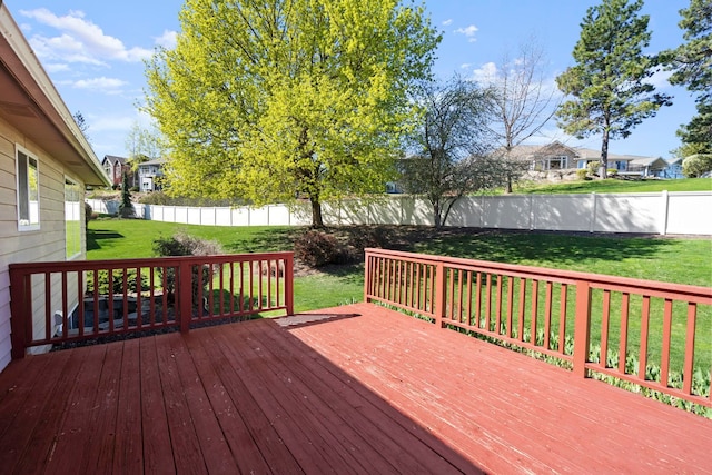 wooden deck featuring a lawn, a fenced backyard, and a residential view