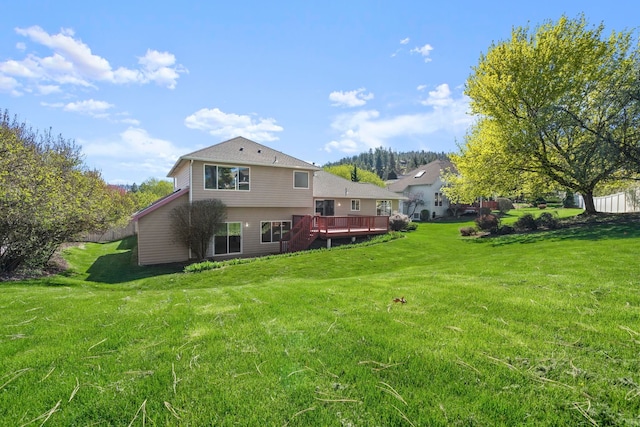 back of house featuring a wooden deck and a yard