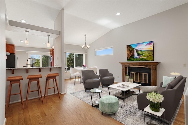 9701 W Masters Ln, Cheney, WA 99004 - living room with light wood finished floors, vaulted ceiling, a chandelier, a glass covered fireplace, and recessed lighting