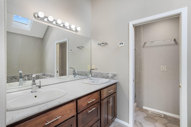 9701 W Masters Ln, Cheney, WA 99004 - bathroom featuring a skylight, double vanity, a shower, decorative backsplash, and vaulted ceiling
