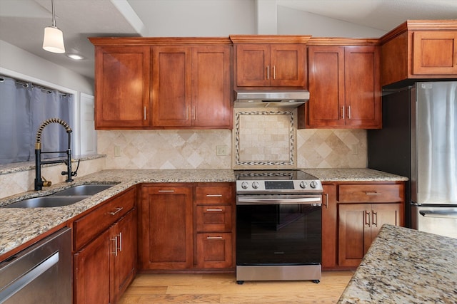 9701 W Masters Ln, Cheney, WA 99004 - kitchen with appliances with stainless steel finishes, under cabinet range hood, light wood-style flooring, light stone countertops, and lofted ceiling
