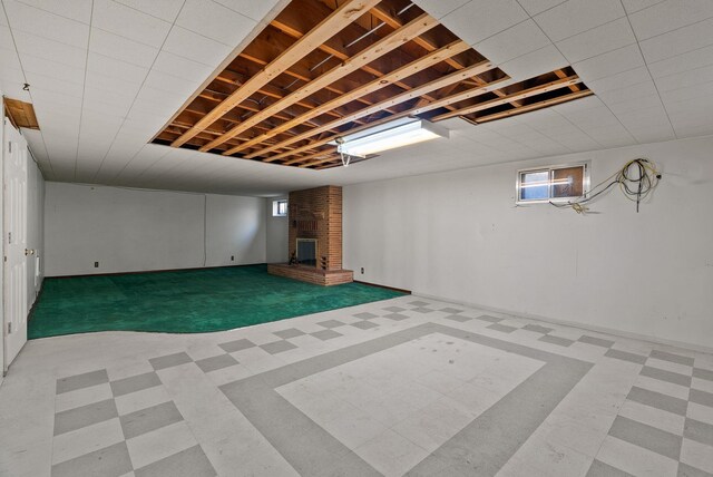 basement with a fireplace, a healthy amount of sunlight, and tile patterned floors