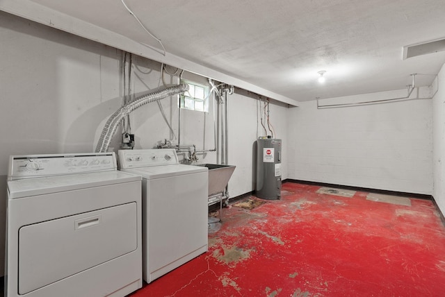 laundry room featuring water heater, washer and dryer, laundry area, and a sink