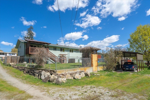 rear view of property with a detached carport and fence private yard