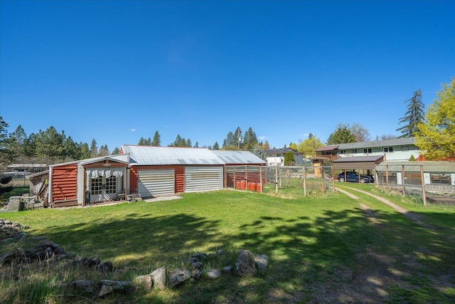 view of yard featuring fence, an outbuilding, and a pole building