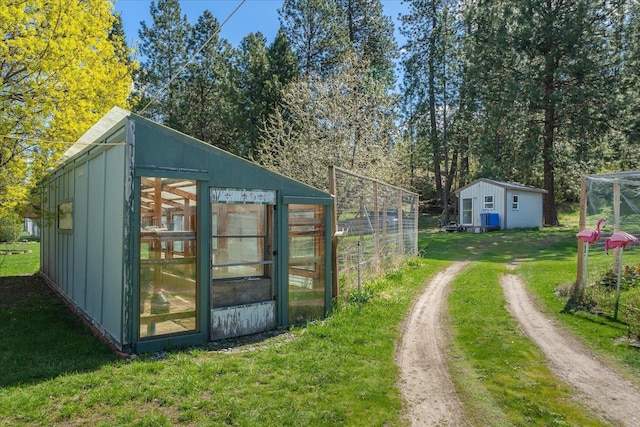 view of greenhouse featuring a lawn and driveway