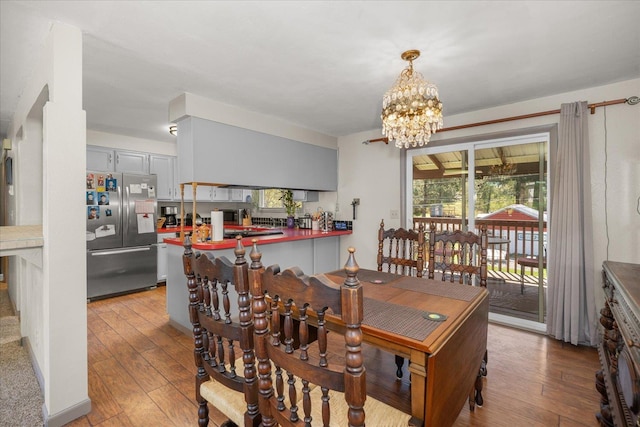 dining space with plenty of natural light, a notable chandelier, and wood-type flooring