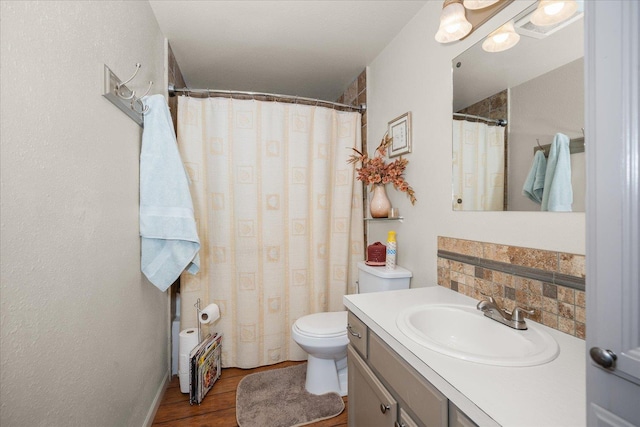 bathroom featuring wood finished floors, decorative backsplash, vanity, toilet, and a shower with shower curtain