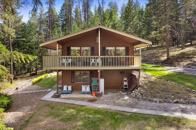 back of house featuring a wooden deck and a patio