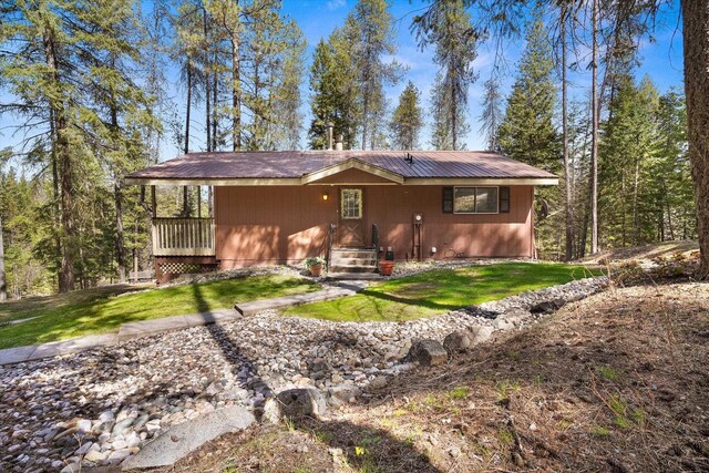 rear view of house with a lawn and metal roof