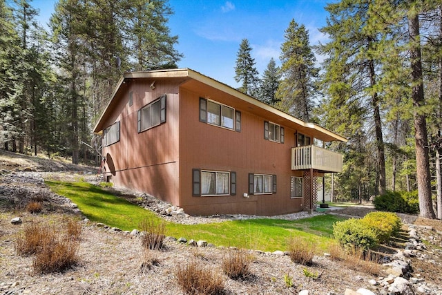 view of property exterior featuring a lawn and a balcony