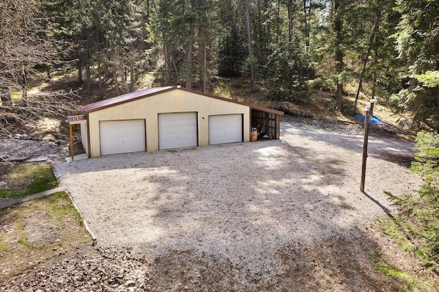 detached garage featuring a forest view