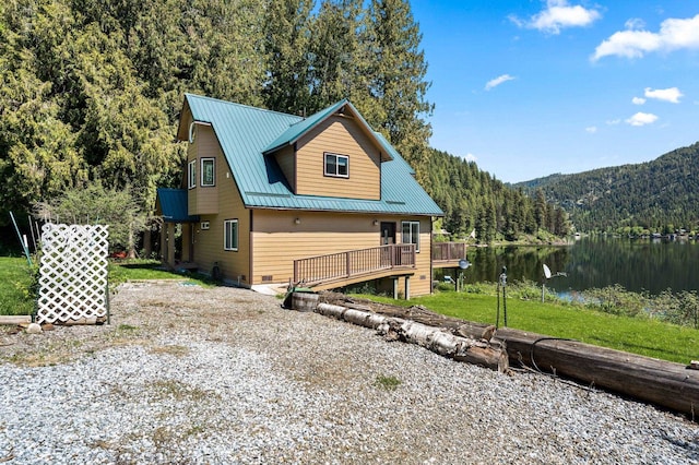 2876 Deep Lake S Shore Rd, Colville, WA 99114 - back of property featuring a forest view, a metal roof, and a deck with water view