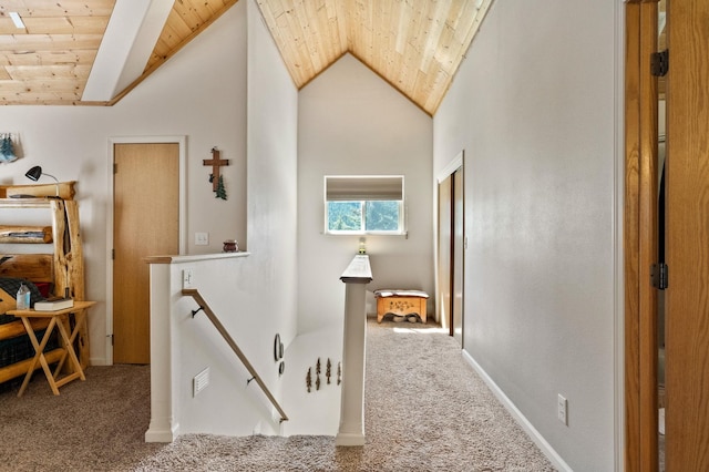 hall with lofted ceiling, wooden ceiling, carpet flooring, and an upstairs landing