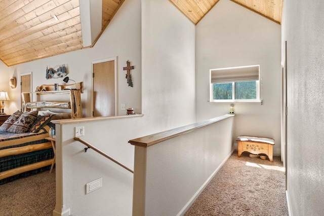 corridor with wood ceiling, lofted ceiling, an upstairs landing, and carpet