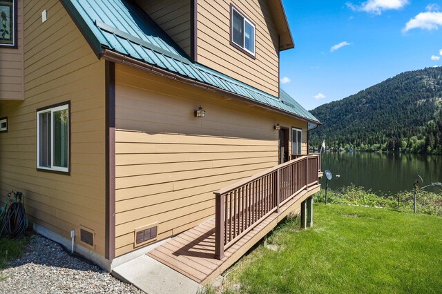 2876 Deep Lake S Shore Rd, Colville, WA 99114 - view of side of home featuring a metal roof, a lawn, a water and mountain view, and a forest view