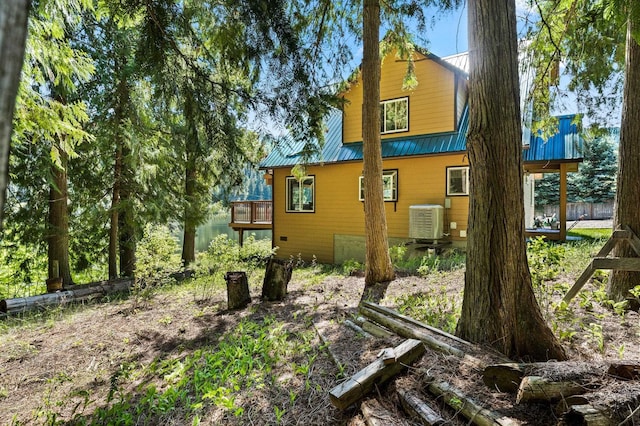 view of side of home with a deck and metal roof