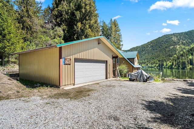 exterior space with a wooded view and a water and mountain view