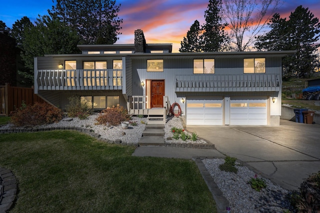 view of front of house featuring a chimney, fence, a yard, driveway, and a garage