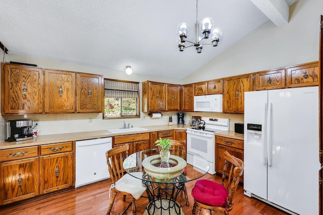 kitchen with a sink, white appliances, decorative backsplash, lofted ceiling with beams, and brown cabinetry