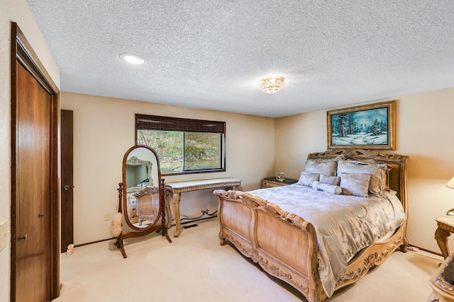 bedroom featuring light carpet, a textured ceiling, and recessed lighting