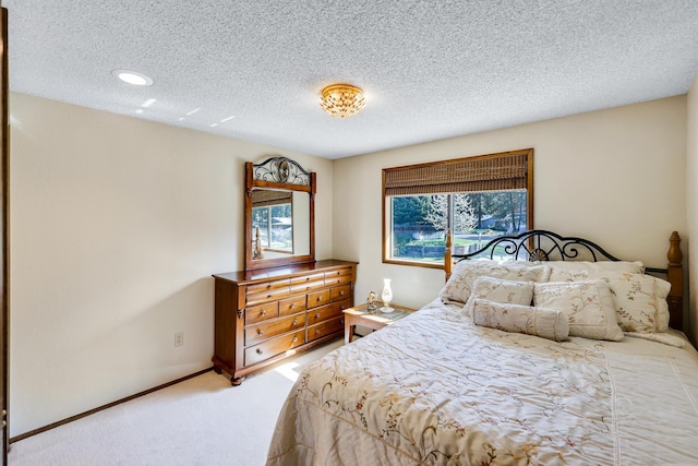 bedroom with a textured ceiling, recessed lighting, and light colored carpet