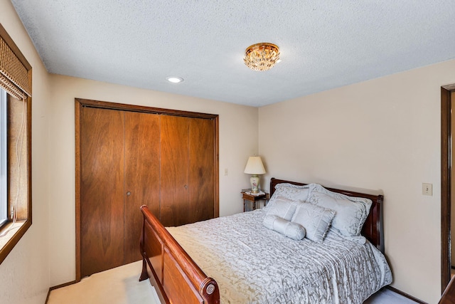 bedroom with recessed lighting, a textured ceiling, a closet, and light carpet
