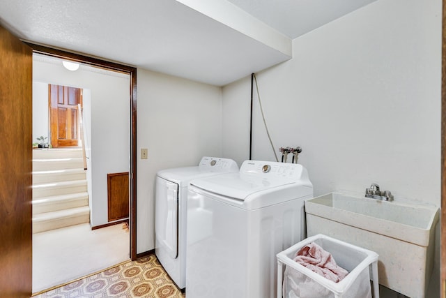 washroom featuring a sink, washer and dryer, and laundry area