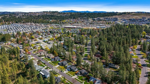 drone / aerial view featuring a residential view, a wooded view, and a mountain view