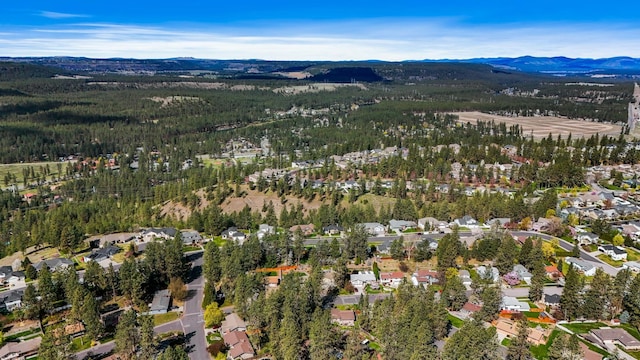 drone / aerial view featuring a residential view, a wooded view, and a mountain view
