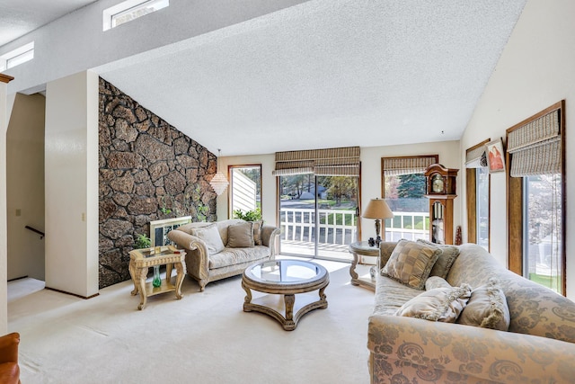 living area with vaulted ceiling, carpet floors, a stone fireplace, and a textured ceiling