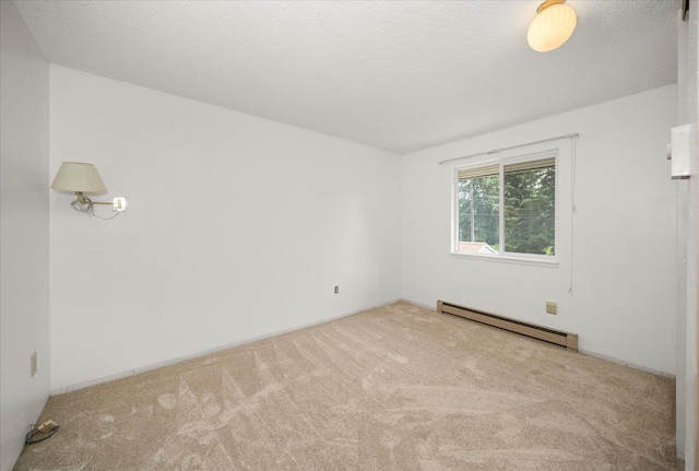 spare room with a baseboard heating unit and carpet flooring