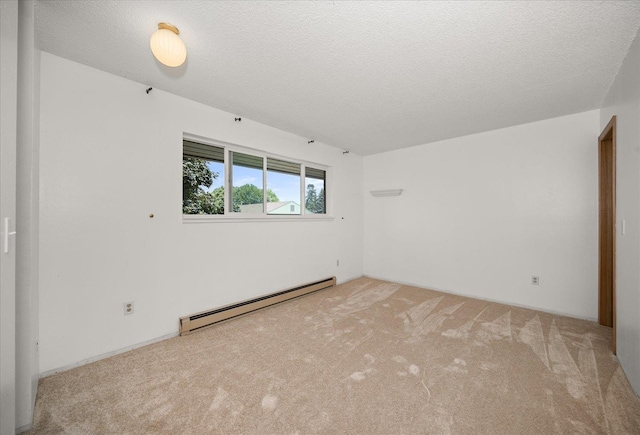 carpeted empty room featuring a textured ceiling and baseboard heating