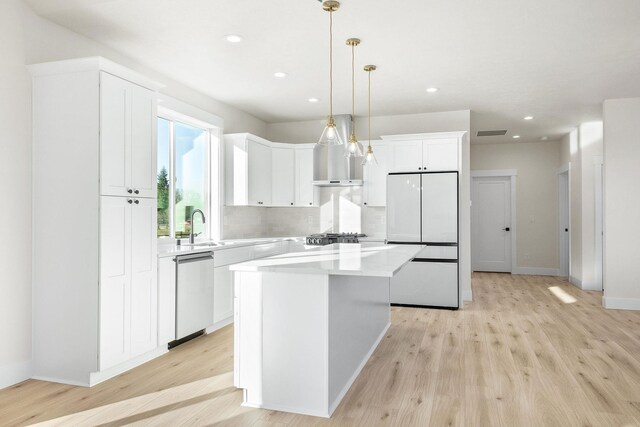 kitchen with a center island, white cabinetry, light wood-style flooring, appliances with stainless steel finishes, and recessed lighting
