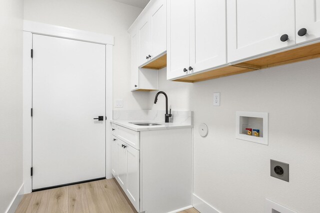 washroom with hookup for an electric dryer, a sink, light wood-style flooring, cabinet space, and washer hookup