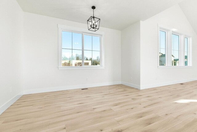 unfurnished dining area featuring a chandelier, light wood-type flooring, a wealth of natural light, and baseboards