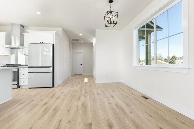 unfurnished dining area with recessed lighting, light wood-type flooring, visible vents, and an inviting chandelier