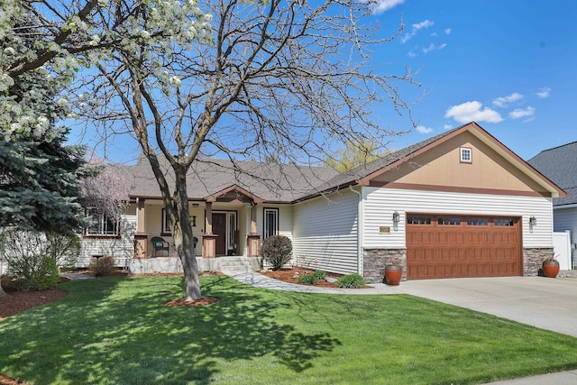 view of front of property featuring an attached garage, driveway, a front lawn, and stone siding
