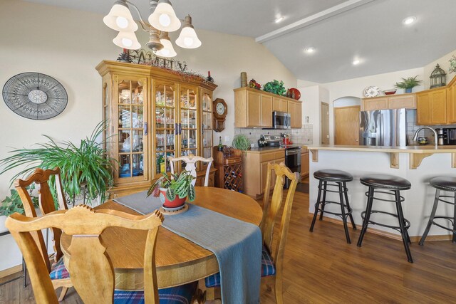 dining area with lofted ceiling with beams, arched walkways, recessed lighting, a notable chandelier, and wood finished floors
